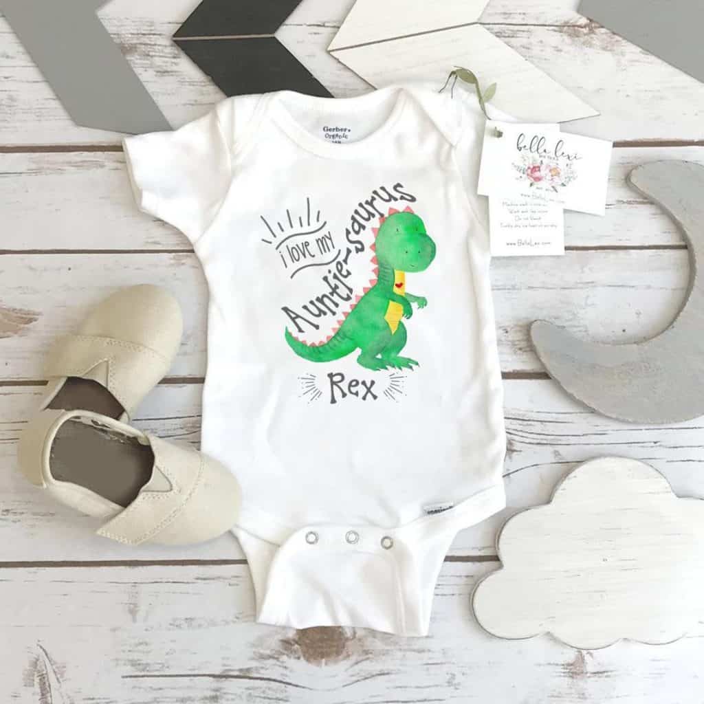 White Aunt Baby Bodysuit with the picture of a dinosaur.