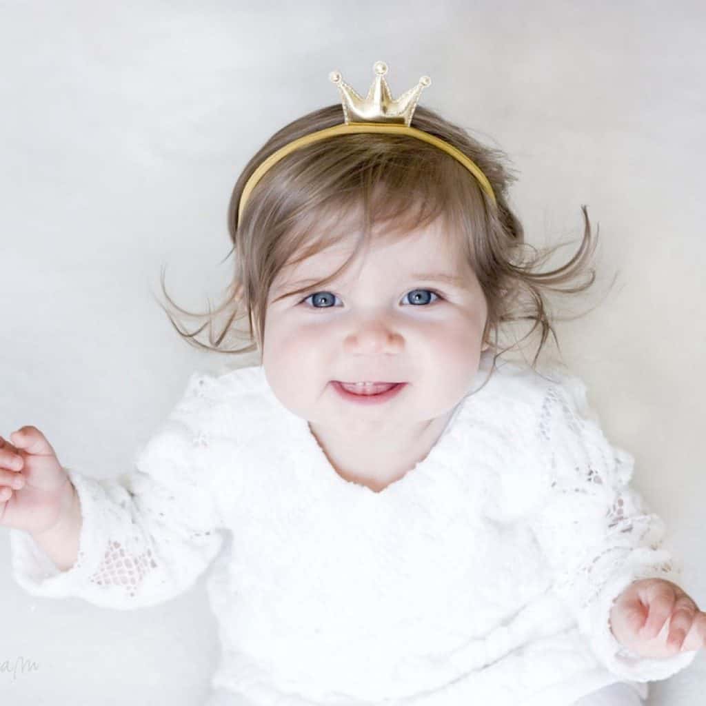 A baby girl wearing a Princess Gold Headband