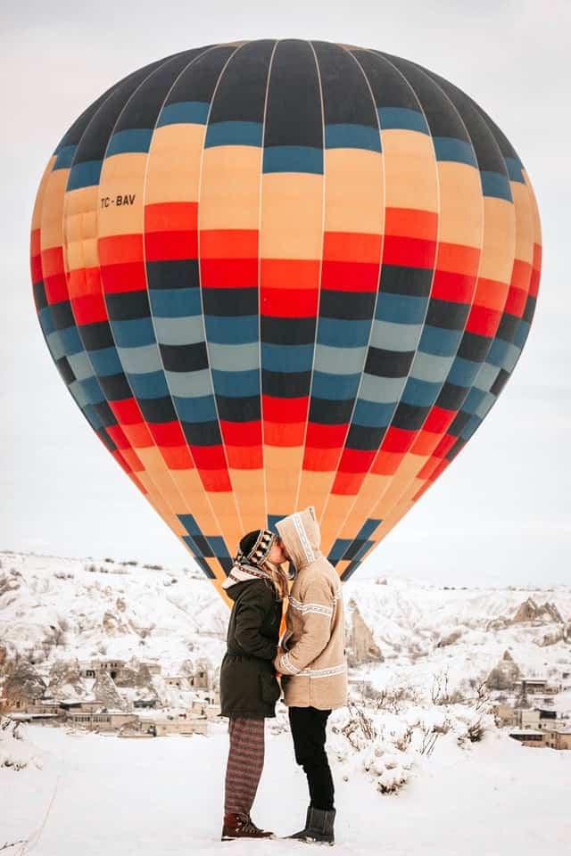 kissing in front of hot air balloon - gift of experience for the bride