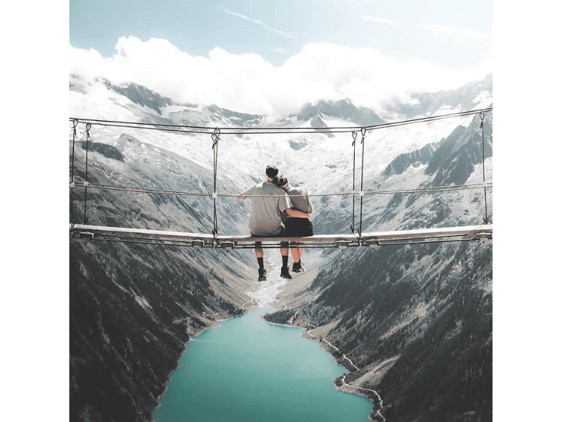 a couple sitting on a hanging bridge - adventurous activity for one year anniversary